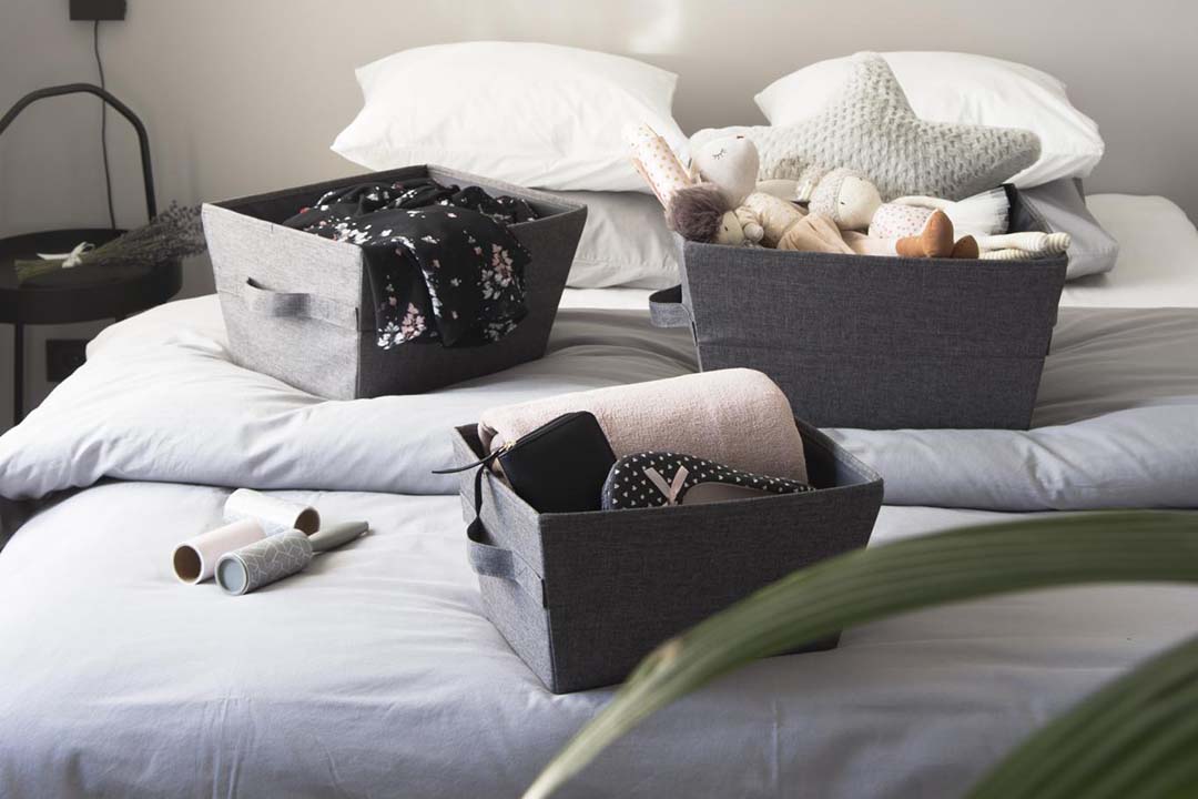 Grey Fabric Tapered Storage Bins on a bed